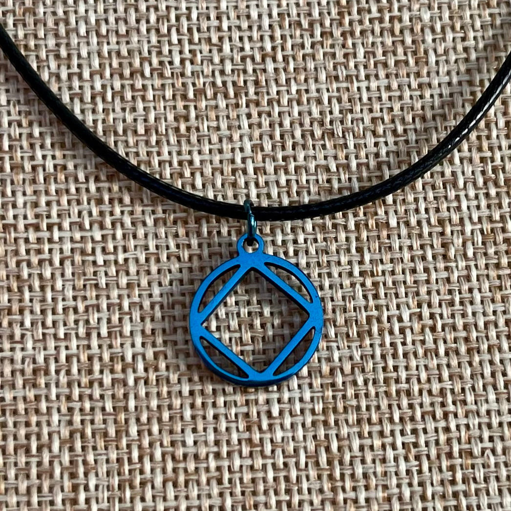 Adjustable necklace with a blue stainless steel narcotics anonymous symbol charm, displayed on a burlap background.