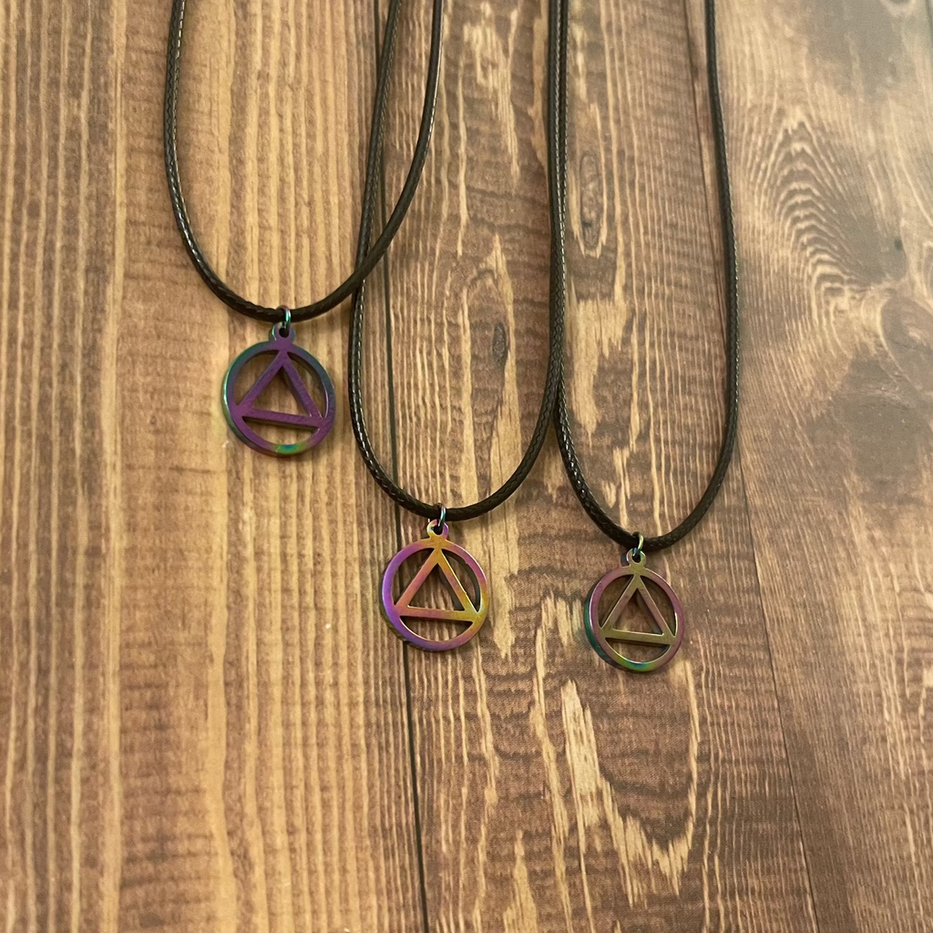 Two necklaces with AA pendants on a wooden surface