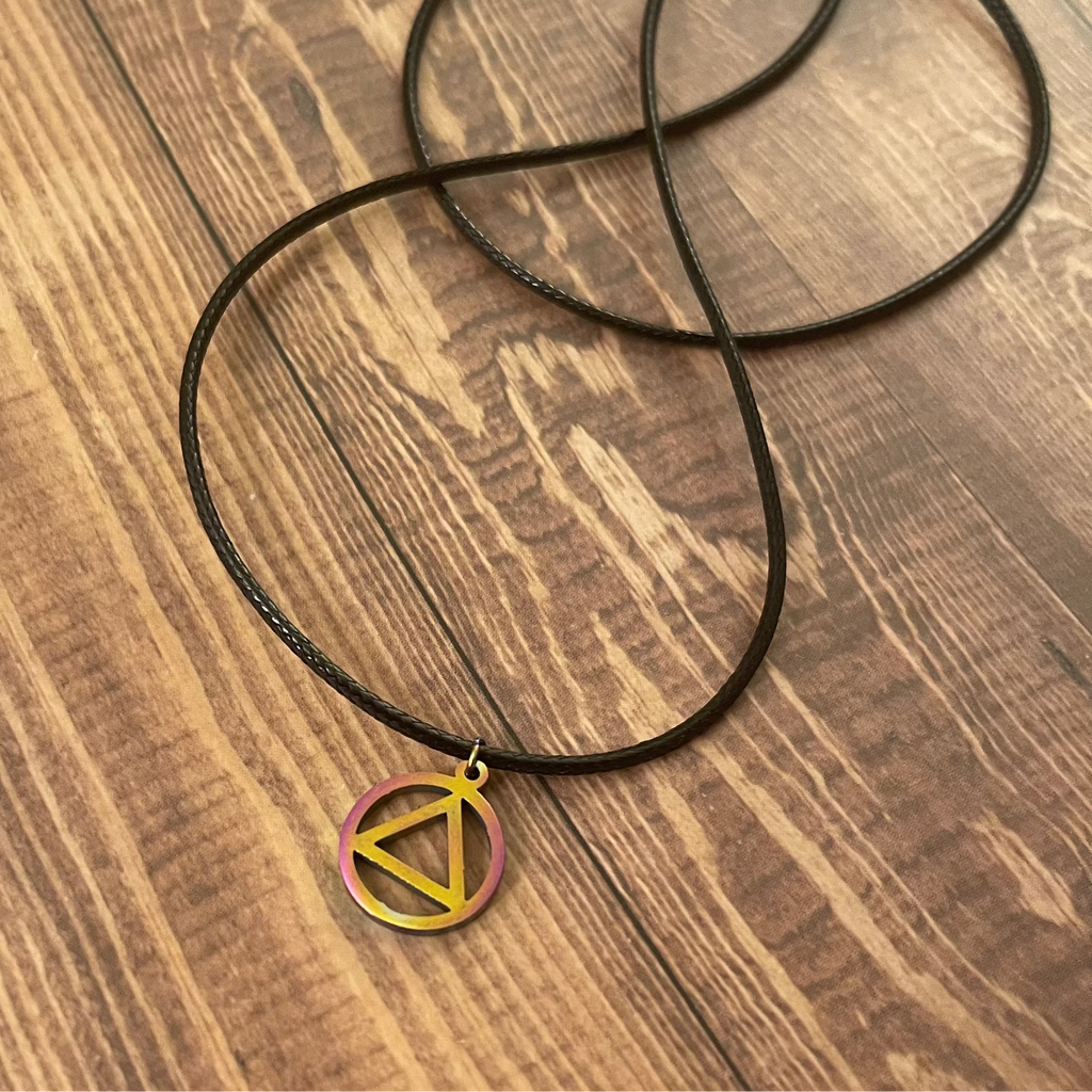 Necklace with a triangle pendant on a wooden surface