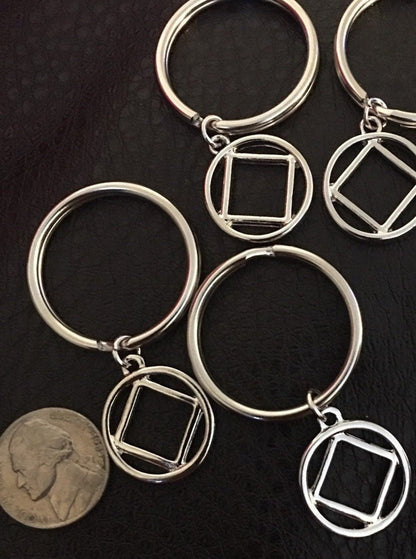 A nickel next to the charms to show size comparison